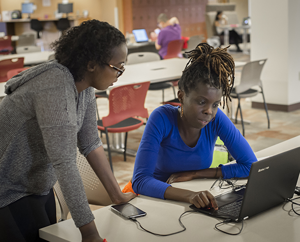 two people looking over laptop