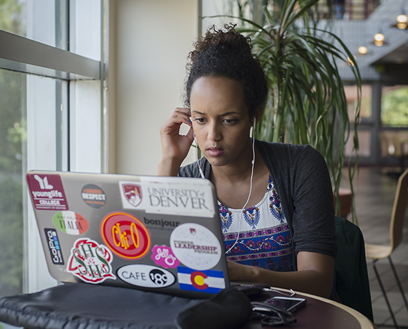student wearing headphones using laptop