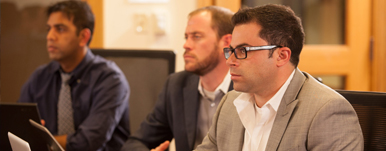 Three men paying attention in class.